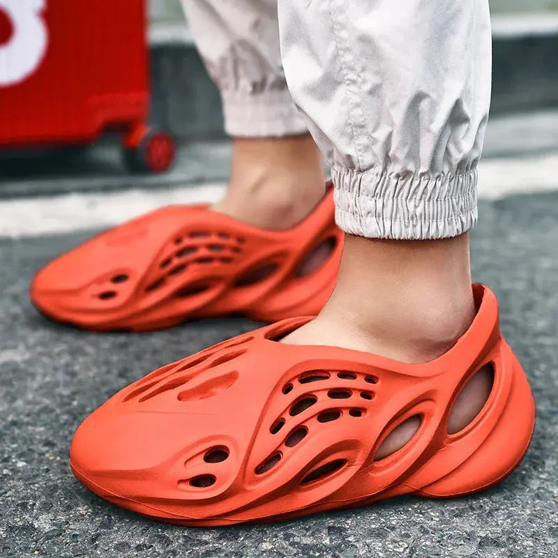Bright orange slip-on foam shoes with cutout design on feet, street style fashion