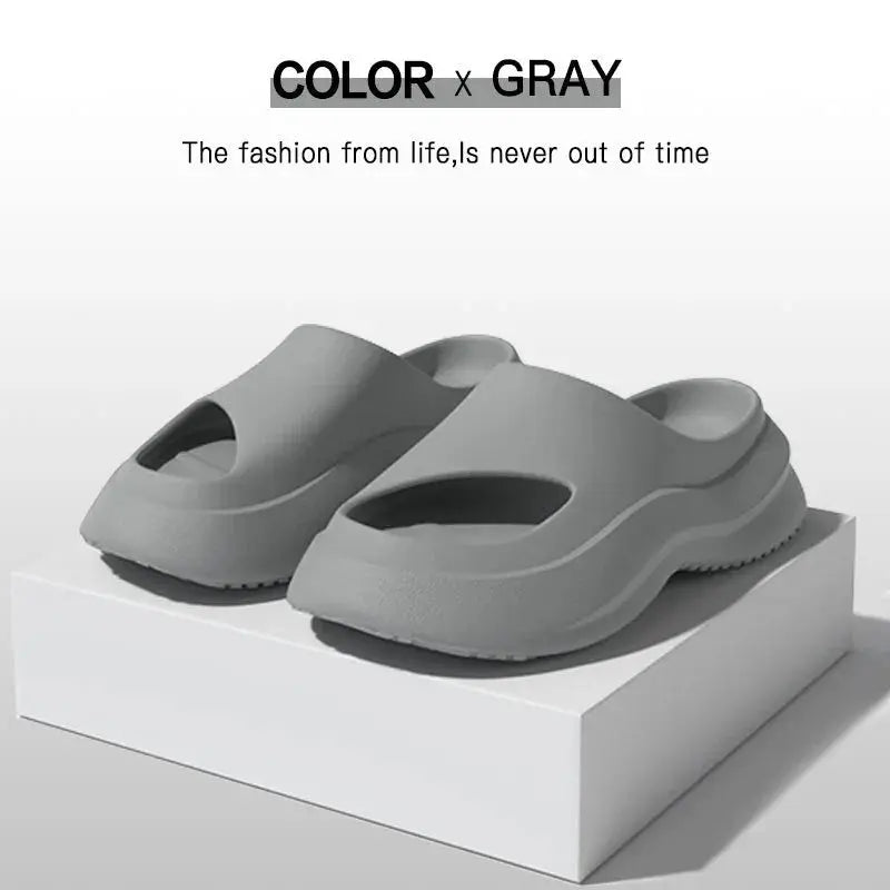 Gray slide sandals with open toe design displayed on a white platform, minimalist style