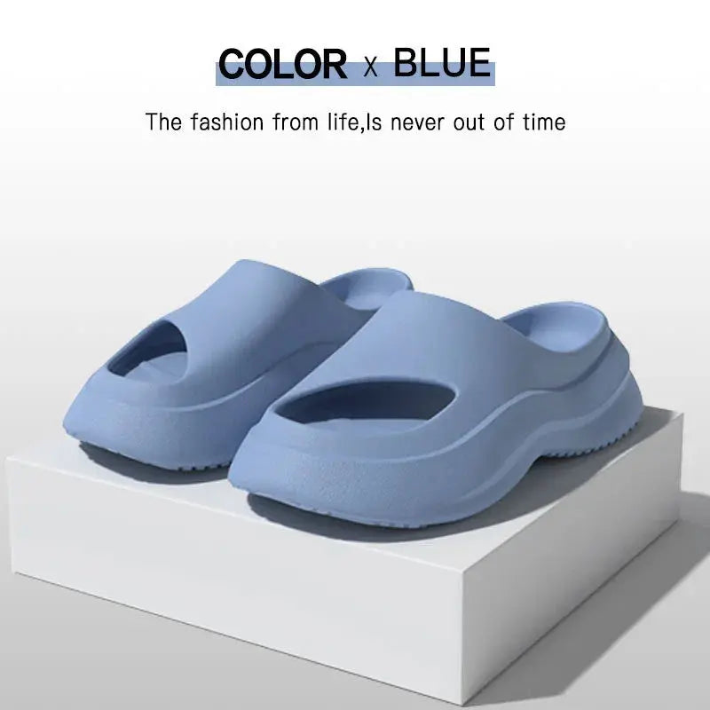 Blue ergonomic slide sandals with open toes, displayed on a white platform.
