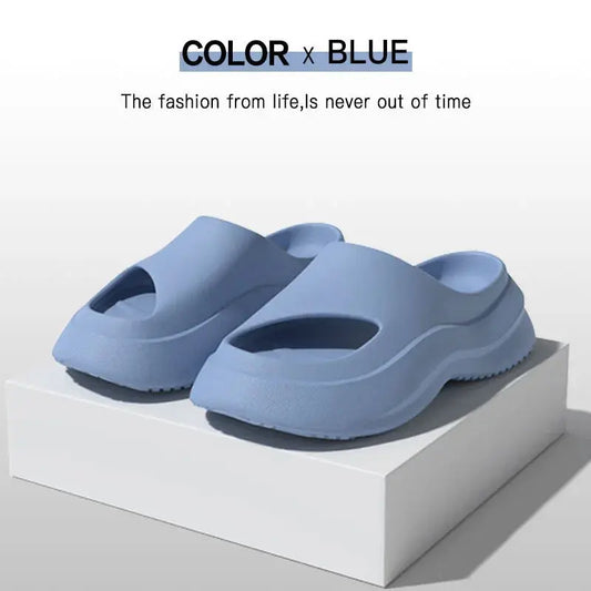 Blue ergonomic slide sandals with open toes, displayed on a white platform.