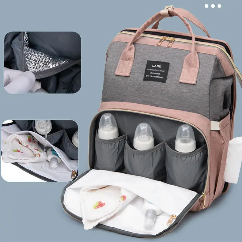 Gray and pink canvas diaper bag backpack with thermal insulation, bottle holders, and side wipe dispenser pocket.