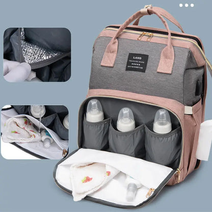 Gray and pink canvas diaper bag backpack with thermal insulation, bottle holders, and side wipe dispenser pocket.