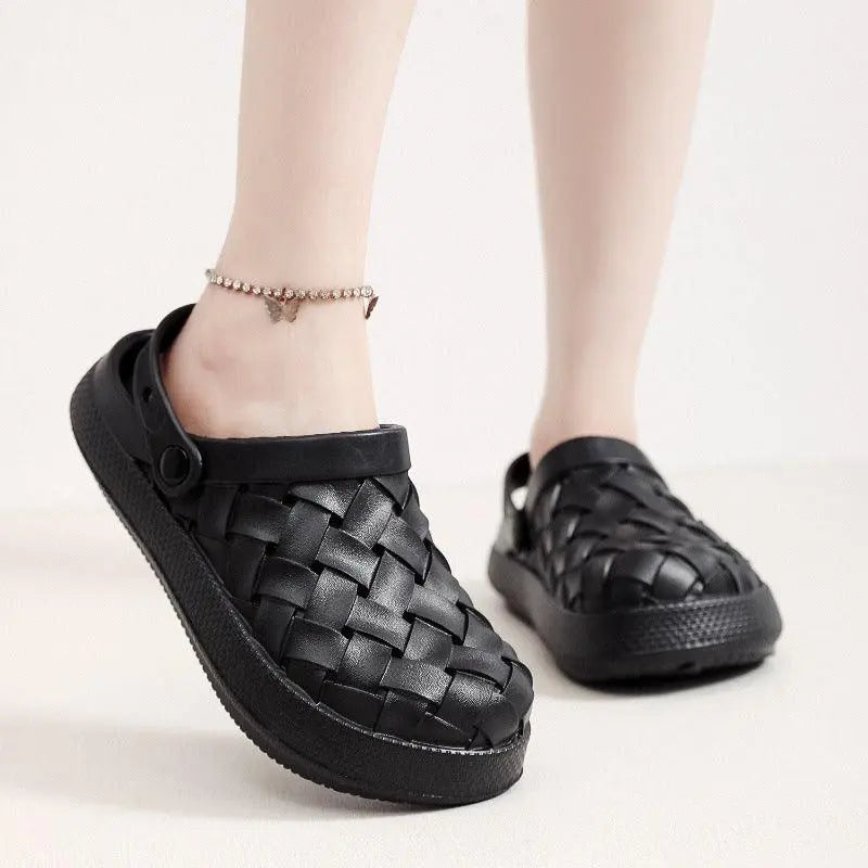 Black woven slip-on clogs with ankle strap, casual footwear on light background.