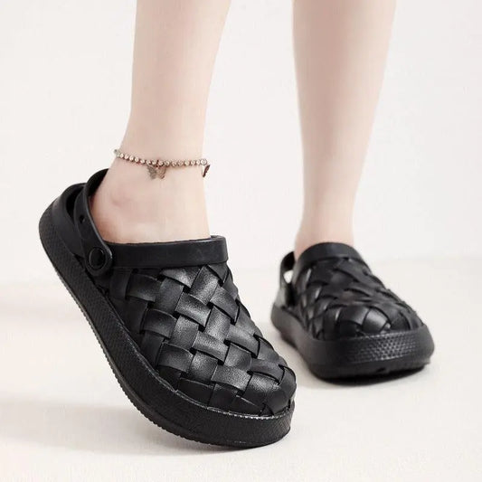Black woven slip-on clogs with ankle strap, casual footwear on light background.