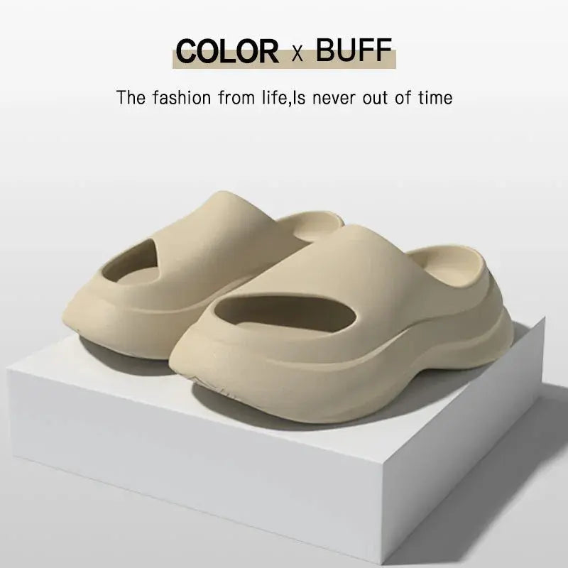 Beige foam slides with thick soles on white display, minimalist modern footwear